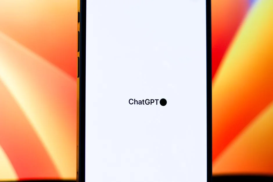 Close-up of hands using smartphone with ChatGPT app open on screen.
