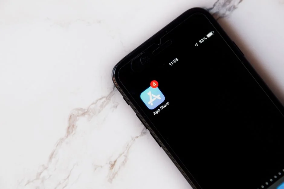 Personne en train de se détendre à l’intérieur avec un café et un smartphone, en train d’écrire des messages dans un cadre chaleureux.